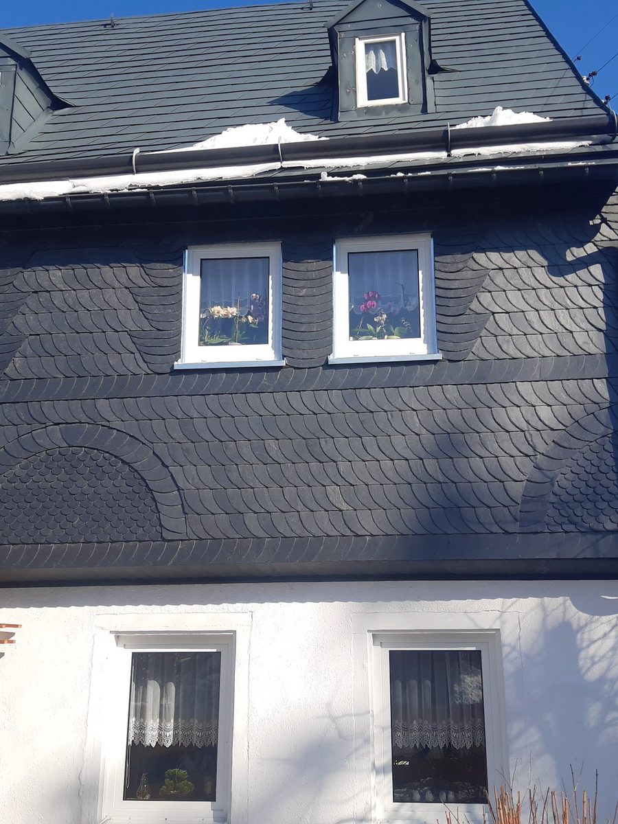 Haus mit Schieferfassade und zwei Gauben