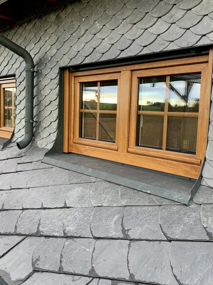Holzfenster in einer Schieferfläche eingefasst